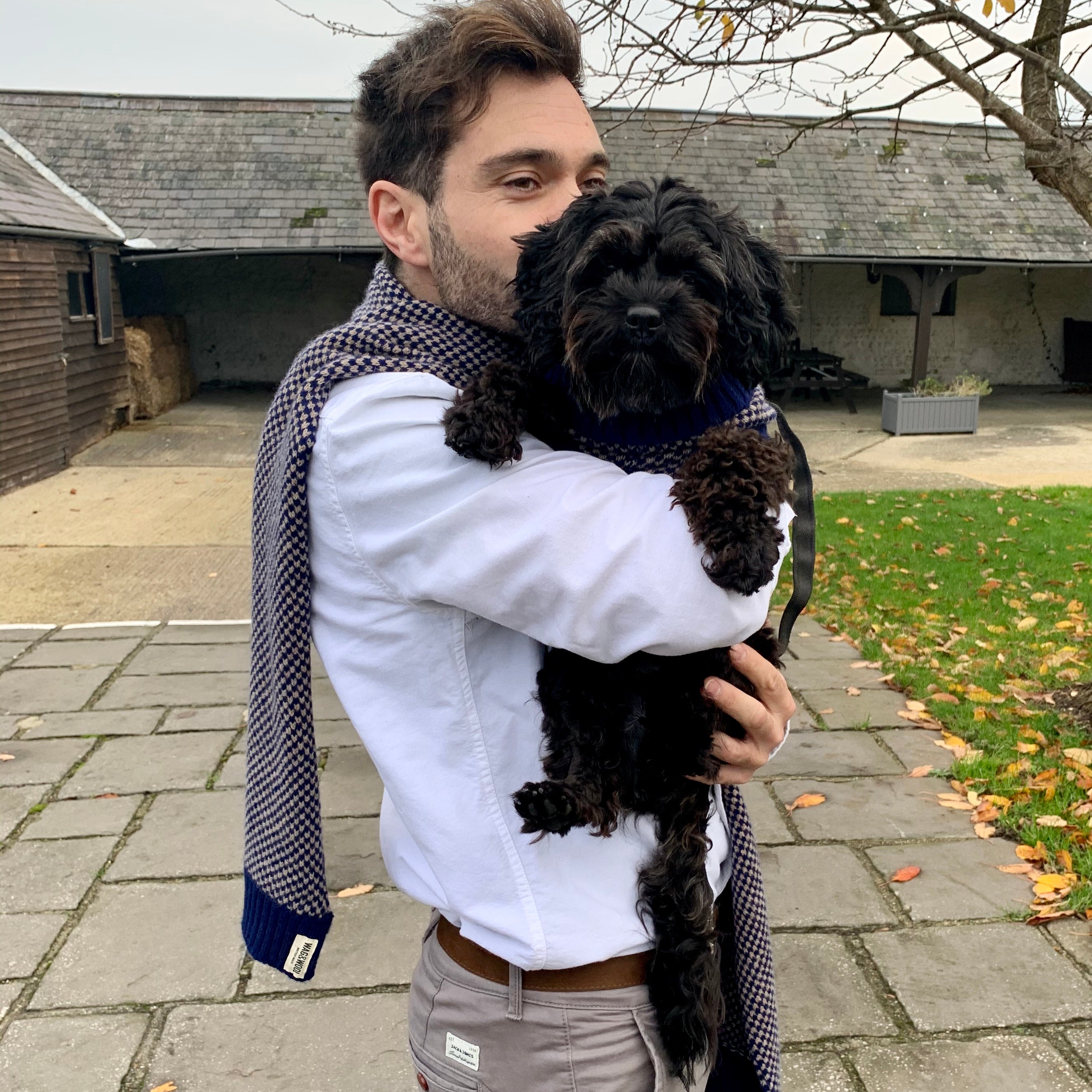 man in a Mens Navy Wool Scarf holding a small dog