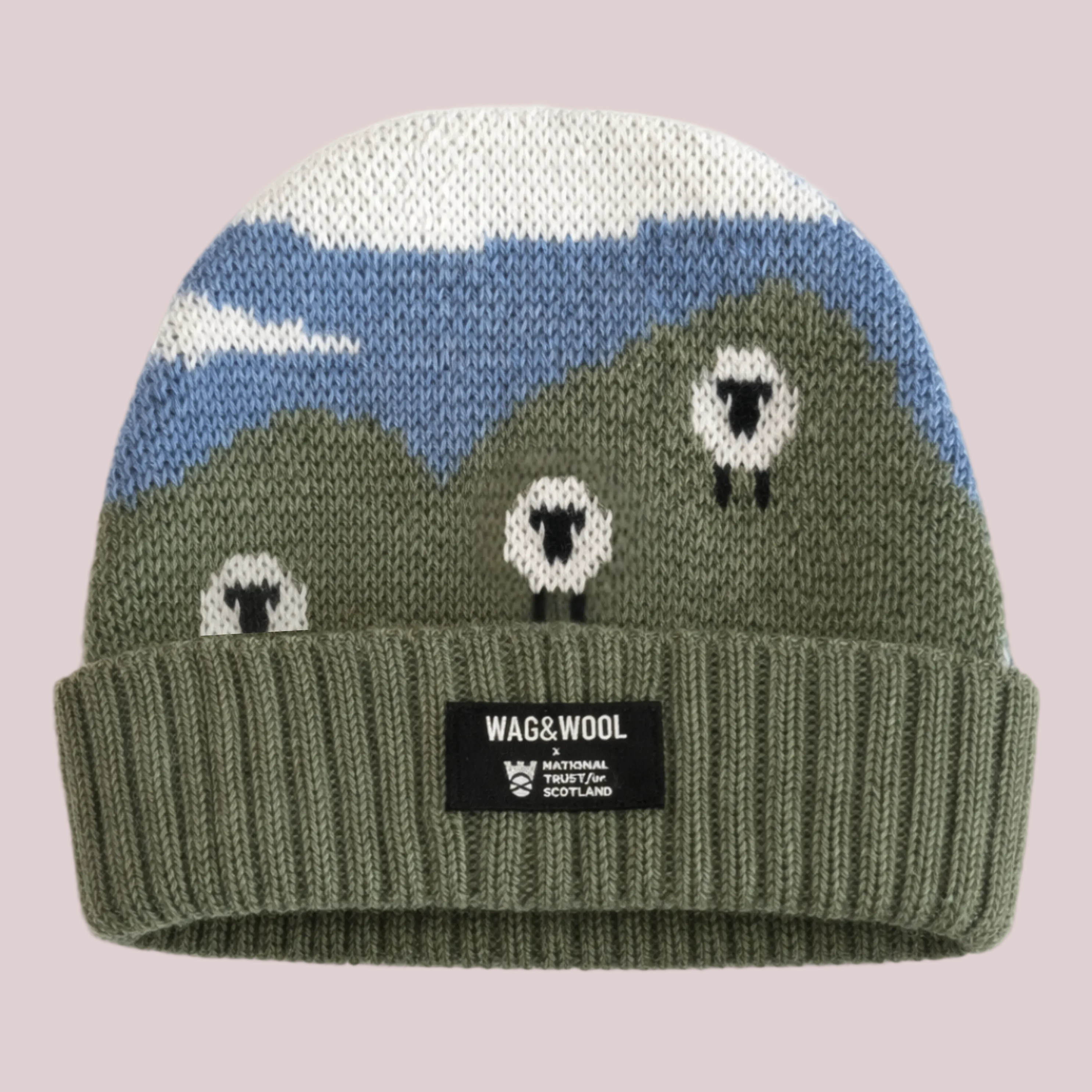 Knitted beanie with mountain and sheep design on a white background