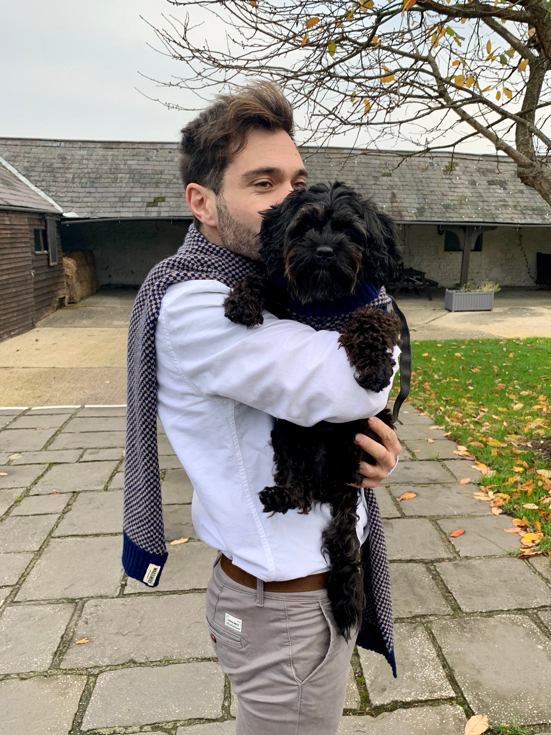 man in a Mens Navy Wool Scarf holding a small dog