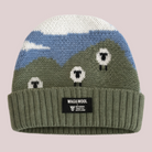 Knitted beanie with mountain and sheep design on a white background