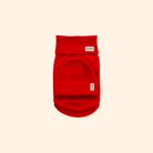 Red dog sweater with a brand label on a beige background